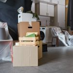 Close up background image of messy cardboard boxes filled with decor in new home, family moving and relocation concept, copy