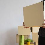 House moving concept. Man holding cardboard box, closeup. Moving boxes in new apartment, real estate