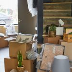 Vertical background image of hallway in new home filled with cardboard boxes, family moving and relocation concept, copy space